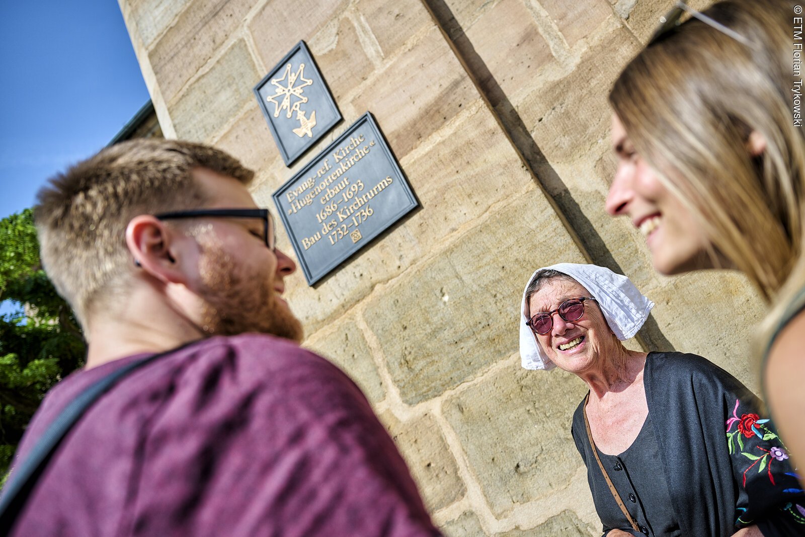 Der Eingang der Hugenottenkirche mit Informationstafel