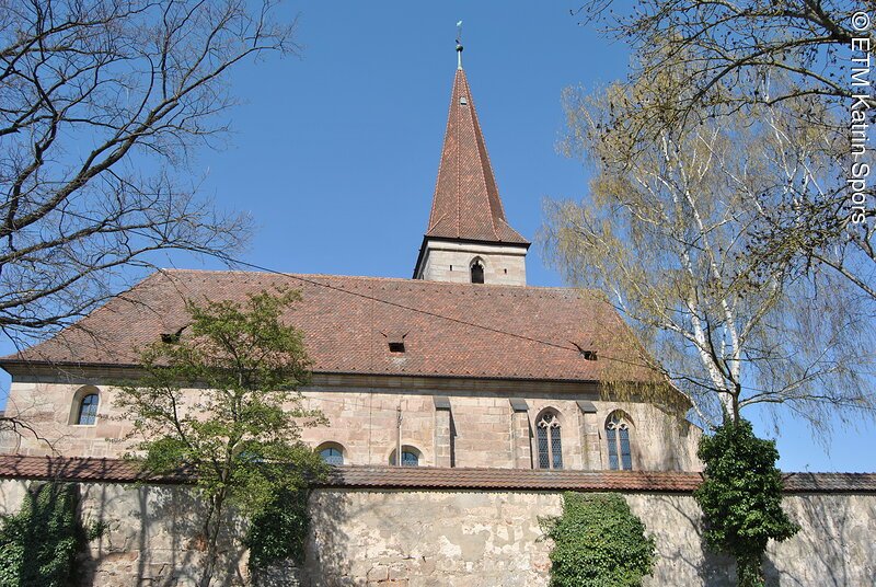 Blick auf die B&uuml;chenbacher Kirche mit gro&szlig;er Mauer im Vordergrund