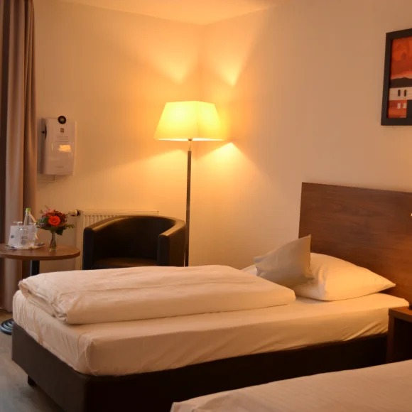 Zwei Einzelbetten, Stehlampen, Bild in einem Hotelzimmer.