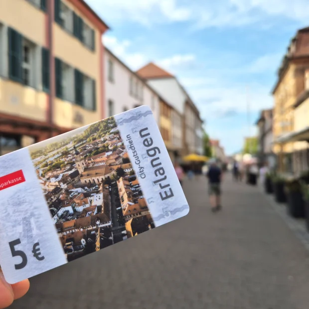 Der fünf Euro City-Gutschein Erlangen auf einer Einkaufsstraße in Erlangen